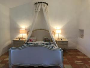 Un pat sau paturi într-o cameră la Le mas jasmins