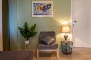 a living room with a chair and a plant at Irini Apartments in Kavála