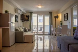a living room with a couch and a table with chairs at Irini Apartments in Kavála