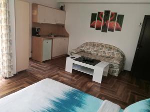 a living room with a couch and a table at Къща за гости ЕЛИ in Primorsko