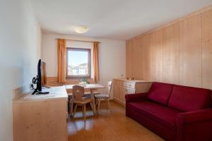 een woonkamer met een rode bank en een tafel bij Apartment 7 - Zur Sonne in Laion
