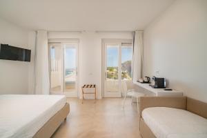 a bedroom with two beds and a view of the ocean at Jatika Boutique Hotel in Aglientu