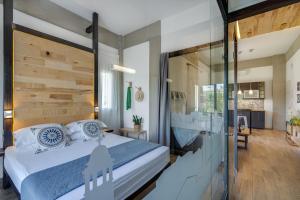 1 dormitorio con 1 cama grande y pared de cristal en Chania Urban Living, en La Canea