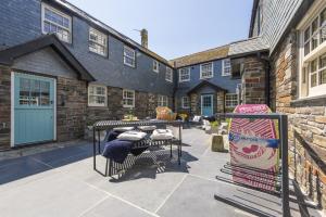 a patio with a table and chairs in front of a building at Iris 5 Star Gold Award Luxury Cottage in St Ives