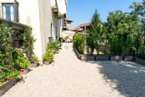 a gravel driveway with plants and a building at La Reggia di Famiglia in Venaria Reale