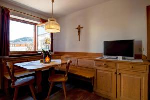 un comedor con mesa y TV y una cruz en la pared en Apartment 1 - Zur Sonne, en Laion