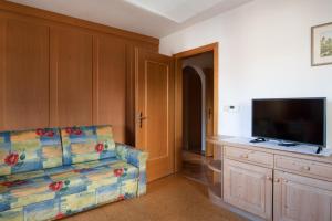 een woonkamer met een bank en een flatscreen-tv bij Apartment 2 - Zur Sonne in Laion