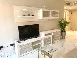 ein Wohnzimmer mit einem TV auf einem weißen Entertainment-Center in der Unterkunft Apartment APOLO XIV in Calpe