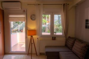 a living room with a couch and two windows at Irini Apartments in Kavála