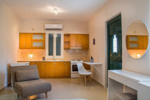 une cuisine avec des placards en bois, une chaise et une table dans l'établissement Blanca Serenidad Luxury Apartment, à Methana