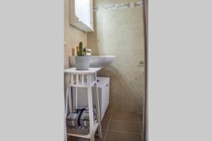 Łazienka z umywalką obok prysznica w obiekcie Blanca Serenidad Luxury Apartment w mieście Methana