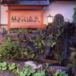 a garden with a rock waterfall and a lantern at Okumizuma Onsen in Kaizuka