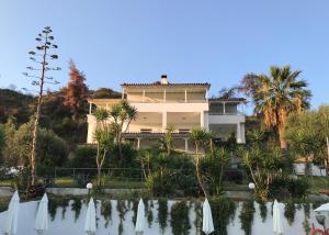 a large house with a pond in front of it at Dias Apartments in Mola Kalyva