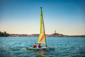 two people on a sail boat in the water at Maistra Select Family Hotel Amarin in Rovinj