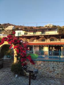 een gebouw met een bos rode bloemen erop bij Mary Popi in Panormos Kalymnos