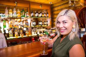 uma mulher sentada num bar com uma bebida em Комплекс отдыха Пампушка & Подушка em Odessa
