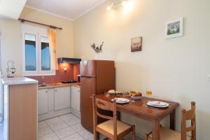 a kitchen with a table and a refrigerator at Casa di Colona Studio in Lixouri +18 photos