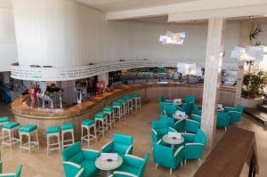 un restaurant avec des tables et des chaises bleues et un comptoir dans l'établissement Son Bauló, à Can Picafort