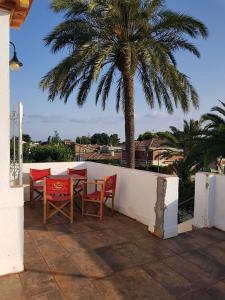 une terrasse avec une table, des chaises et un palmier dans l'établissement Méditerranée Room VILLA BLANCA Cambrils, à Cambrils