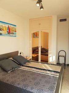 a bedroom with a bed and a room with a sailboat in it at Méditerranée Room VILLA BLANCA Cambrils in Cambrils