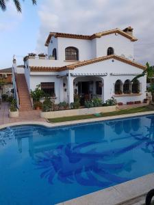 una casa con una gran piscina frente a ella en Méditerranée Room VILLA BLANCA Cambrils, en Cambrils