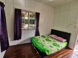 1 dormitorio con 1 cama en una habitación con ventana en Tambatuon Homestead en Kota Belud