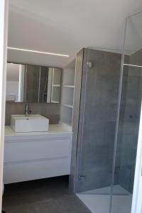 a bathroom with a sink and a shower with a mirror at Ático en el puerto con vistas al mar in A Guarda