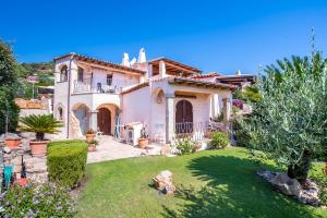 Casa blanca grande con jardín en un patio en villa smeralda en Cannigione