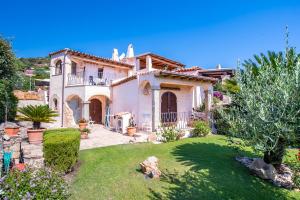 a large white house with a garden in a yard at villa smeralda in Cannigione