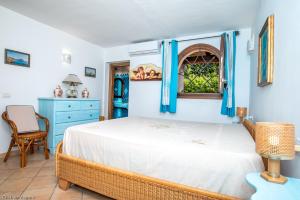 a bedroom with a bed with blue walls and a window at villa smeralda in Cannigione