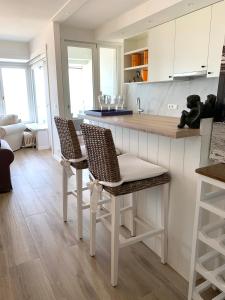 una cocina con encimera y 2 sillas y una isla de cocina en Residentie Rapallo Oostende with fantastic Sea View! en Ostende