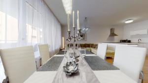 comedor con mesa con sillas blancas y cocina en Apartment Puma v centre Piešťan, en Piešťany