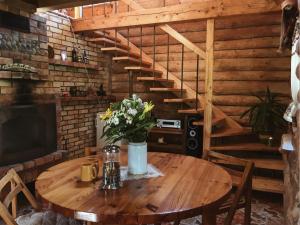 een houten tafel met een vaas met bloemen erop bij Namelis Atokvėpis in Čiuiniukai