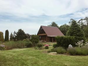 a log cabin with a garden in front of it at Namelis Atokvėpis in Čiuiniukai