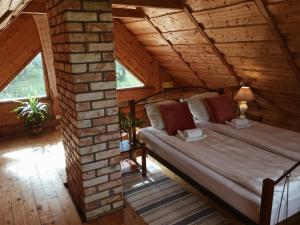 a bedroom with a bed in a wooden house at Namelis Atokvėpis in Čiuiniukai