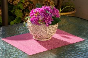 a vase filled with purple flowers sitting on a table at Irini Apartments in Kavála