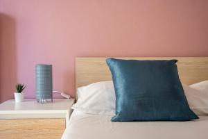 a blue pillow sitting on top of a bed at Irini Apartments in Kavála