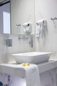 a white bathroom with a sink and a mirror at Smile Inn in Nydri