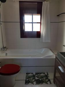 a bathroom with a tub and a toilet and a window at Méditerranée Room VILLA BLANCA Cambrils in Cambrils