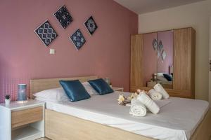 a bedroom with a bed with blue and white pillows at Irini Apartments in Kavála
