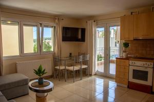 a kitchen and living room with a table and chairs at Irini Apartments in Kavála
