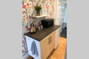 a kitchen with a microwave and a washer and dryer at Tom and Angela’s Place in Liverpool