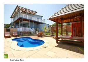 un patio trasero con piscina y una casa en Southview Guest House, en Wollongong