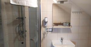 a bathroom with a shower and a sink at Comfort-24 Plus in Słupca