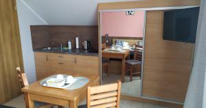 a small kitchen with a table and a dining room at Comfort-24 Plus in Słupca