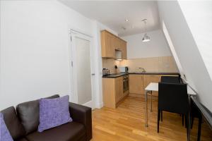 uma sala de estar com um sofá, uma mesa e uma cozinha em Modern 1 Bed Flat for up to 2 people in Holborn, London with free wifi em Londres