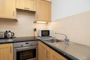 a kitchen with a sink and a microwave at Modern 1 Bed Flat for up to 2 people in Holborn, London with free wifi in London