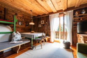1 dormitorio con 1 cama y 1 mesa en una habitación en Kronplatz Ski Lodge, en Valdaora