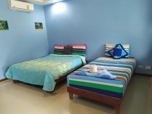 dos camas sentadas una al lado de la otra en una habitación en Ariya Garden Home en Chumphon