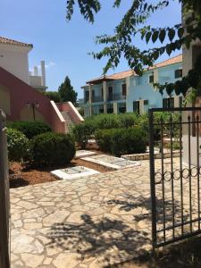 a gate in a courtyard with a building at Georges Estates Hotel in Stoupa